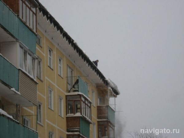 В Бердске борются со снегом на балконных козырьках